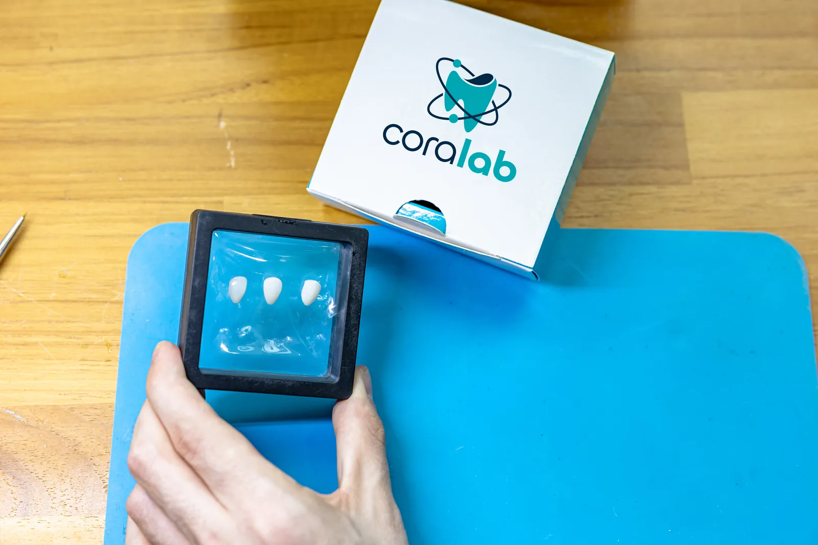 Coroa dental com embalagem Coralab sobre bancada